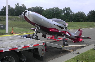Small airplane positioned on ground transport equipment